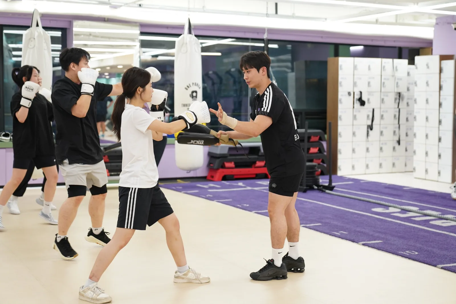 코치가 회원의 자세를 보고 미트를 지도하는 실제 수업